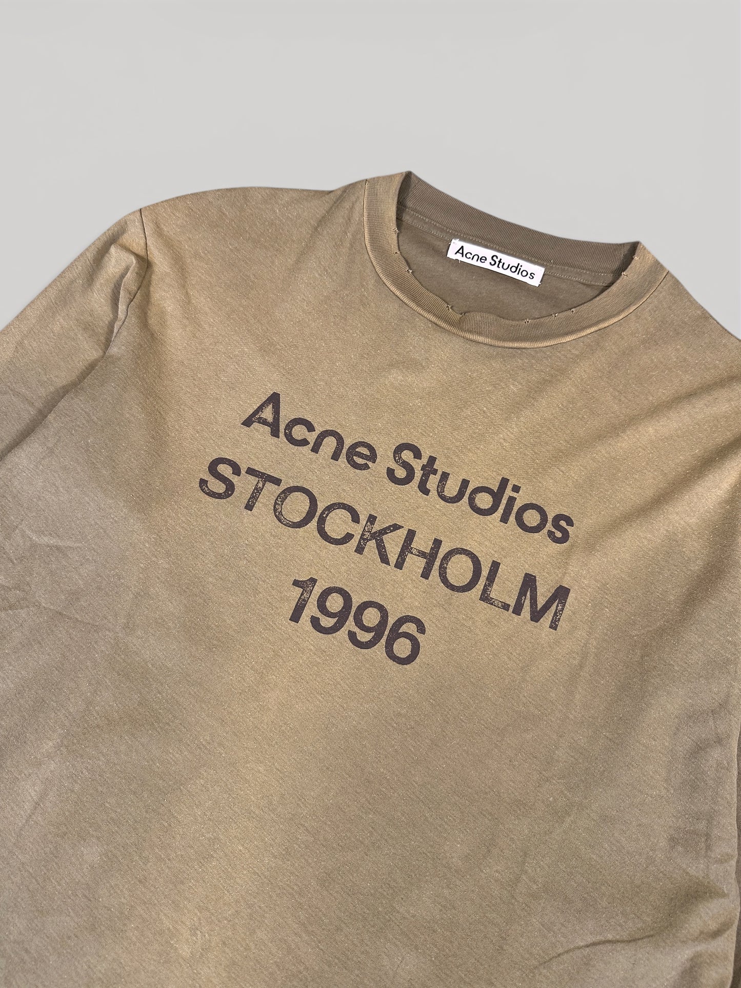 Close-up of the Acne Studios STOCKHOLM 1996 chest print and neck label