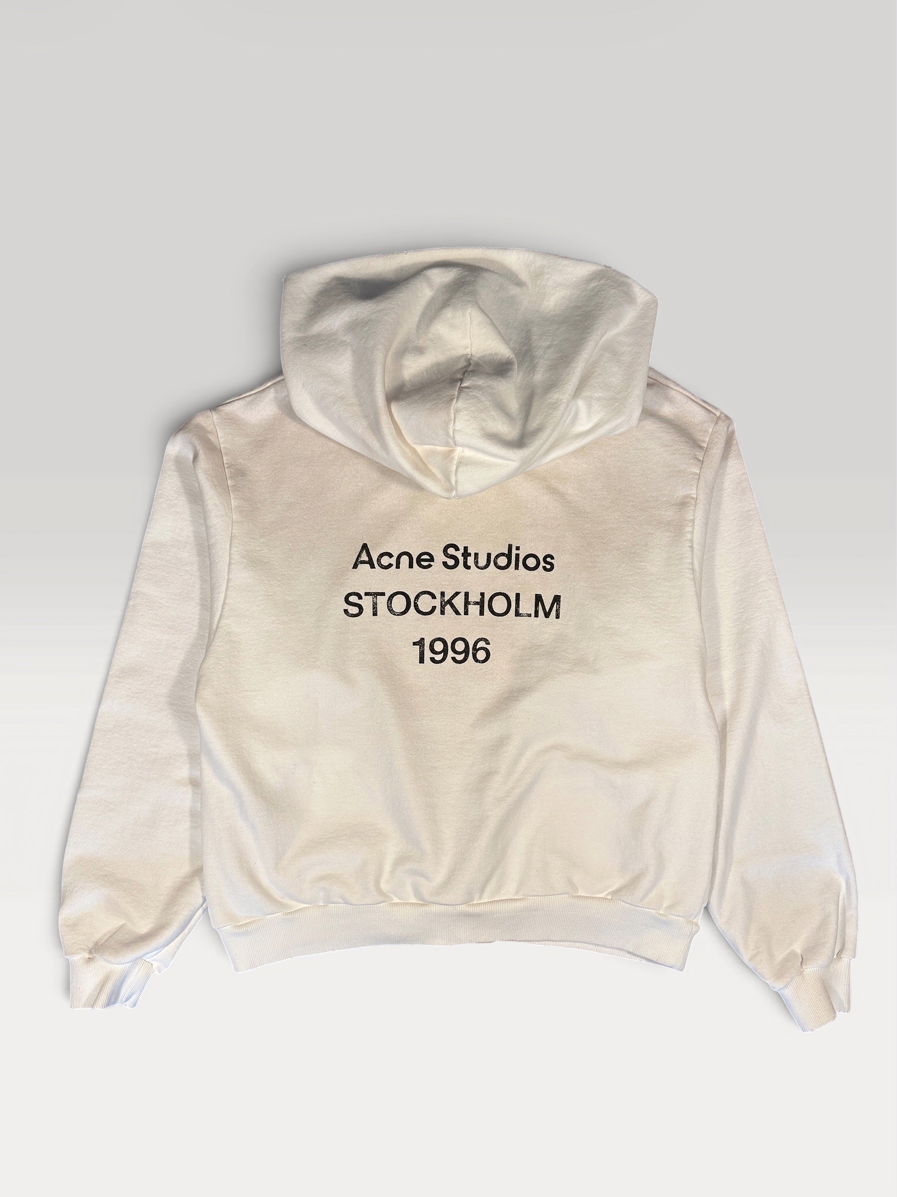 Acne Studios STOCKHOLM 1996 logo print across the back of the off-white hoodie