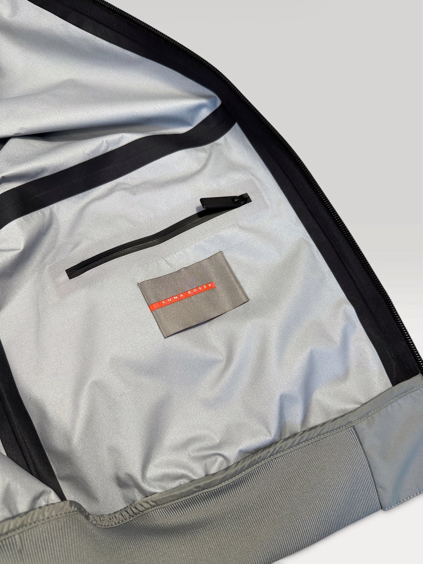 Woven Luna Rossa label and internal zip pocket inside the Prada jacket